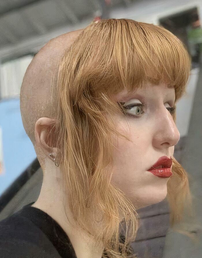 Person with uneven haircut, showing hair accident with shaved head and long bangs.