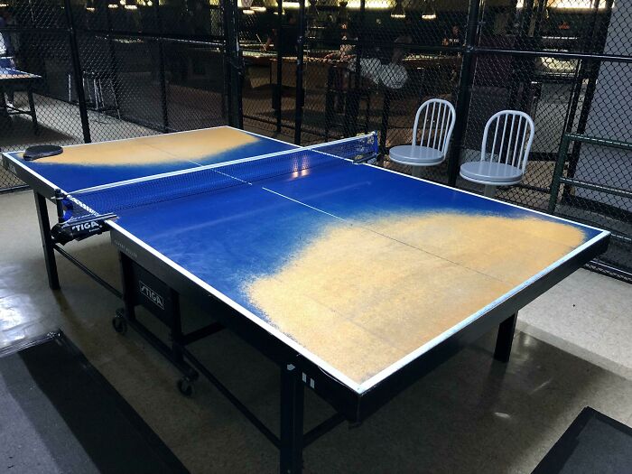 Worn-down ping pong table with faded blue surface illustrating the effects of time.