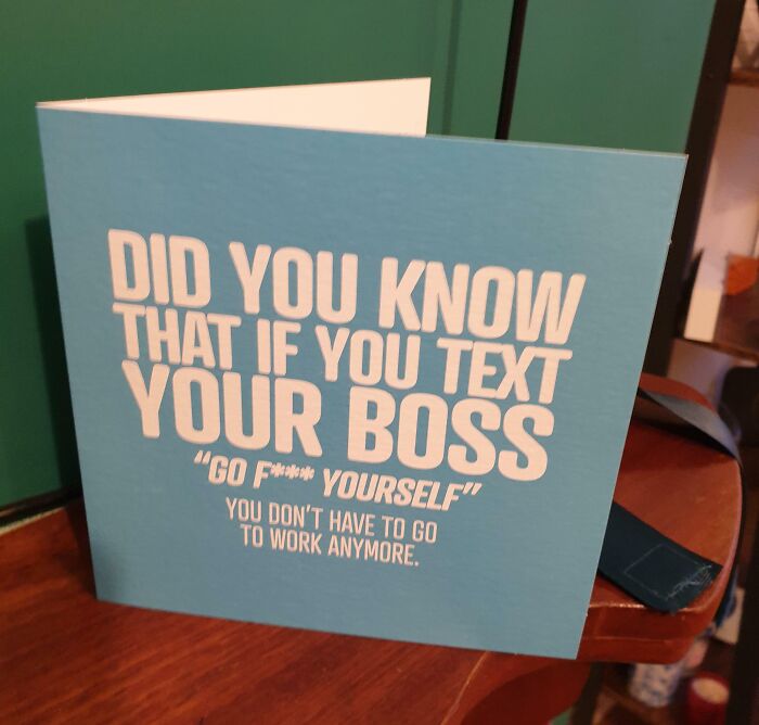 Greeting card humorously addressing people quitting jobs, displayed on a wooden surface.