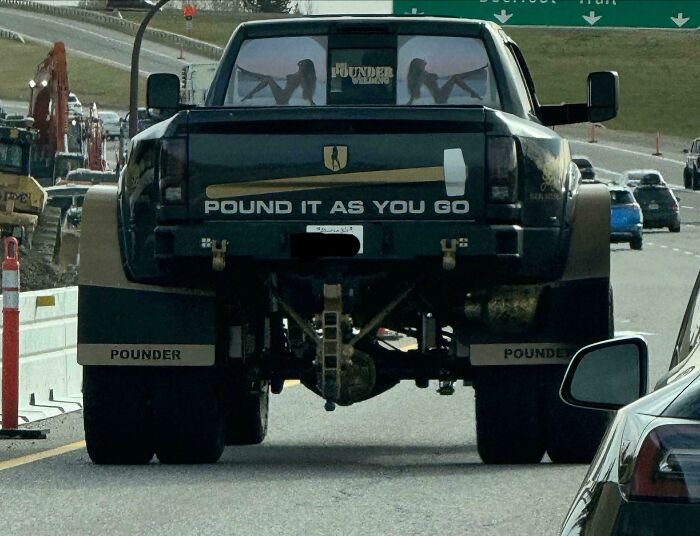 Truck on highway with provocative decals, exhibiting people being complete jerks.