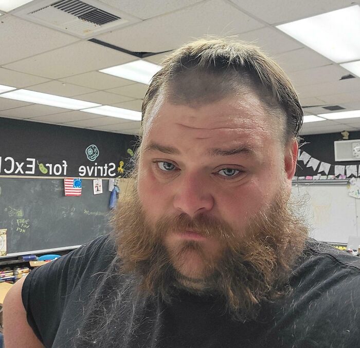 Man in a classroom with uneven haircut, showcasing a tragic hair accident.