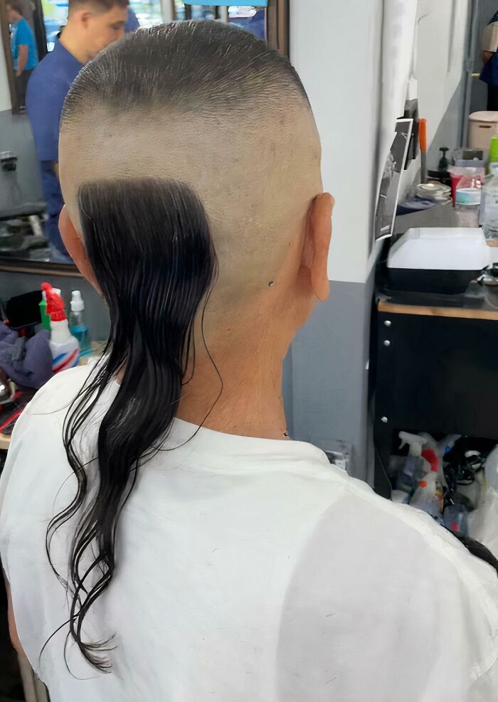 Unusual haircut with a long patch of hair on shaved head; example of a hair accident.