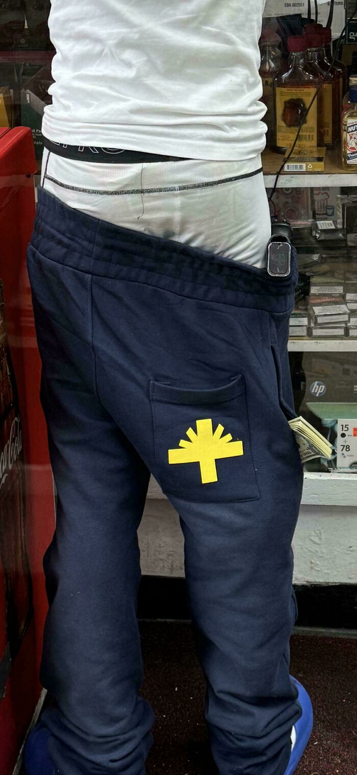 Person standing with pants sagging, revealing underwear in a store, showcasing people being jerks behavior.