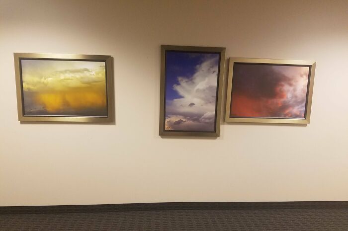 Three mismatched cloud paintings on a wall highlight unfortunate public interior designs.