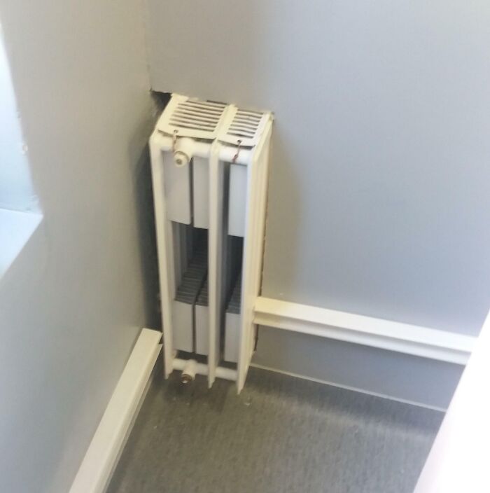 Uneven radiator placement in a corner, highlighting unfortunate public interior designs.