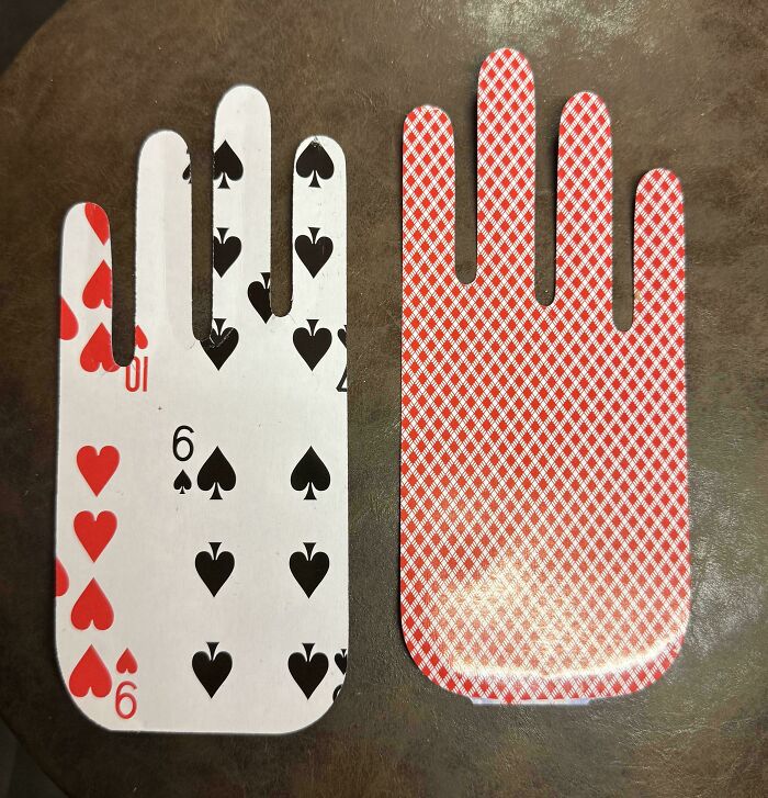 Hand-shaped playing cards on a table, showcasing cool products with surprises.