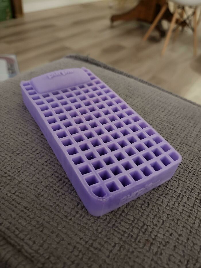 Purple rectangular object with grid pattern on a textured surface, showcasing cool products with surprises.