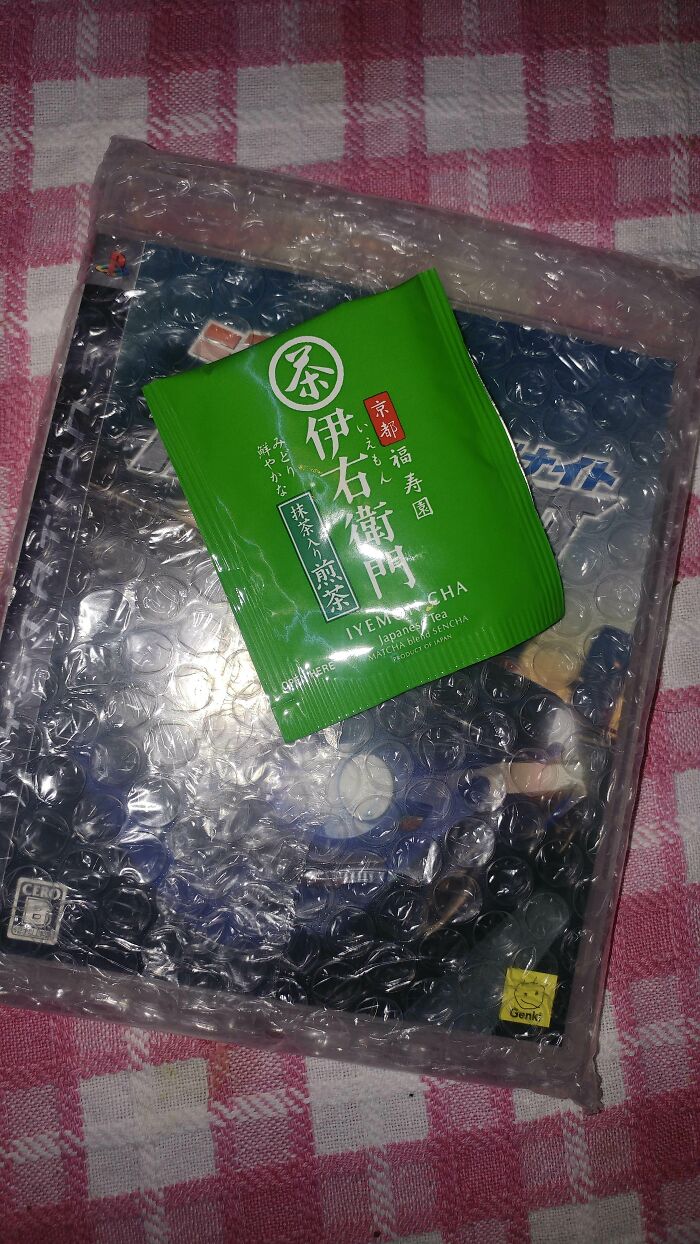 Bubble-wrapped cool product with surprise green tea packet on checkered cloth.