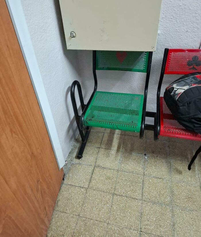 Chair obstructed by wall cabinet in a public space, highlighting unfortunate interior design choices.