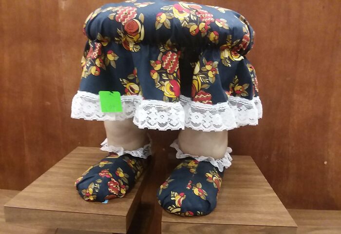 Floral-patterned decorative stool with lace, resembling legs and feet. Creepy things sell online.