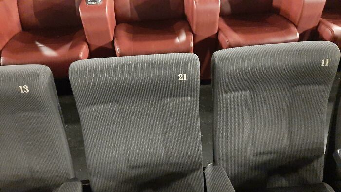 Unfortunate interior design with cinema seats numbered inconsistently, showing 13, 21, and 11 in a row.