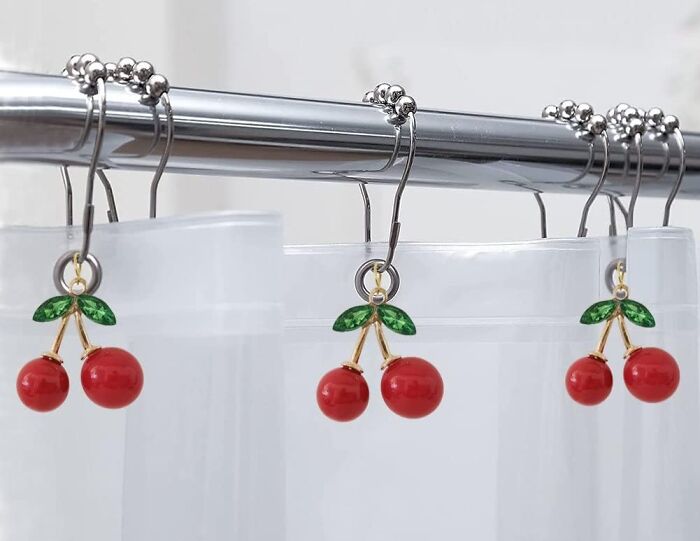 Cherry-themed shower curtain hooks on a rod, adding a pop of dopamine decor with vibrant red and green colors.