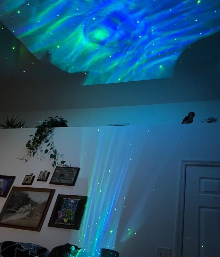 Colorful aurora-like lights projected on a ceiling, creating a tranquil Dopamine Decor effect in a cozy room.