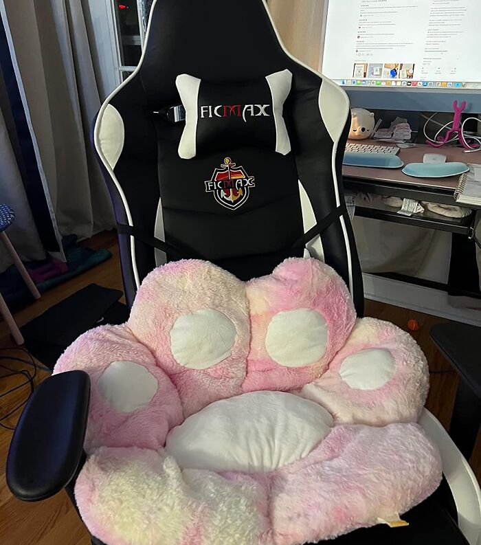 Gaming chair with a pink, plush paw cushion in a cozy room setup, exemplifying dopamine decor.