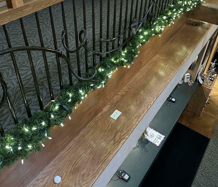 Misplaced handrail on a stairway with decorative lights, showcasing unfortunate public interior design.