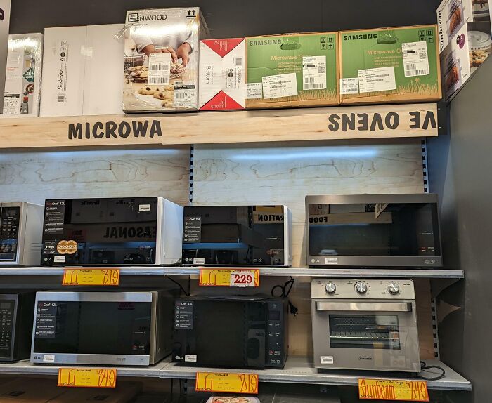 Microwave and oven display with misspelled labels, illustrating unfortunate public interior design.