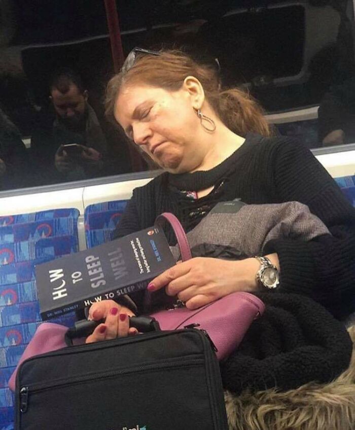 A subway passenger humorously naps holding a book titled "How to Sleep Well."