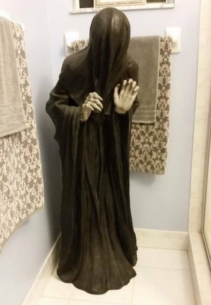 A hooded figure statue in a bathroom, representing creepy things sold online.