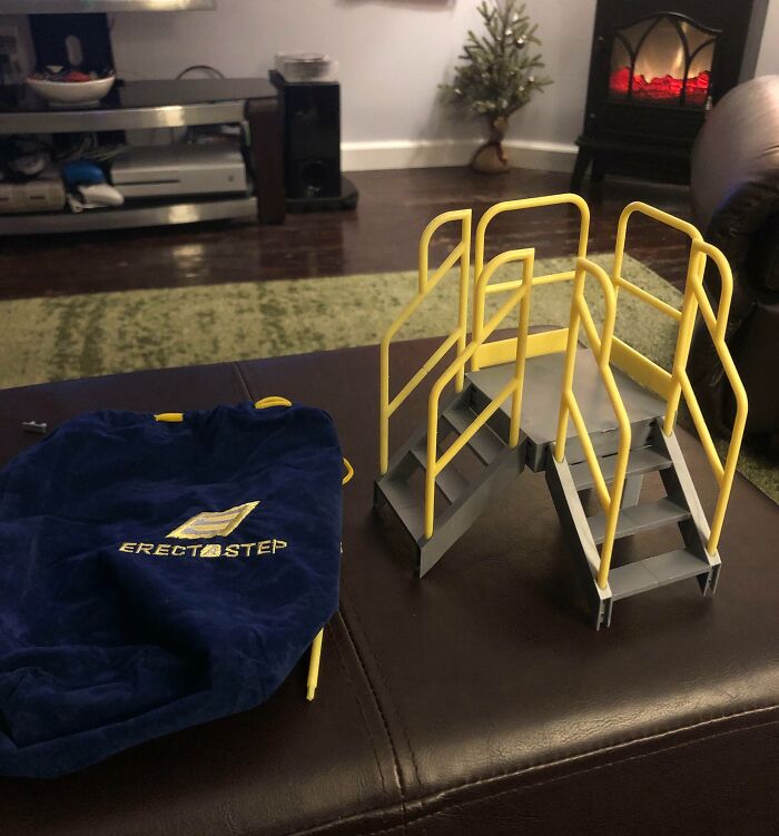 Miniature stair model with yellow railings next to a blue ErectaStep bag, showcasing cool products with surprises.