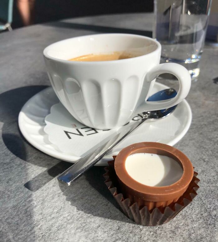 Coffee cup with a chocolate surprise on a sunny table setting.