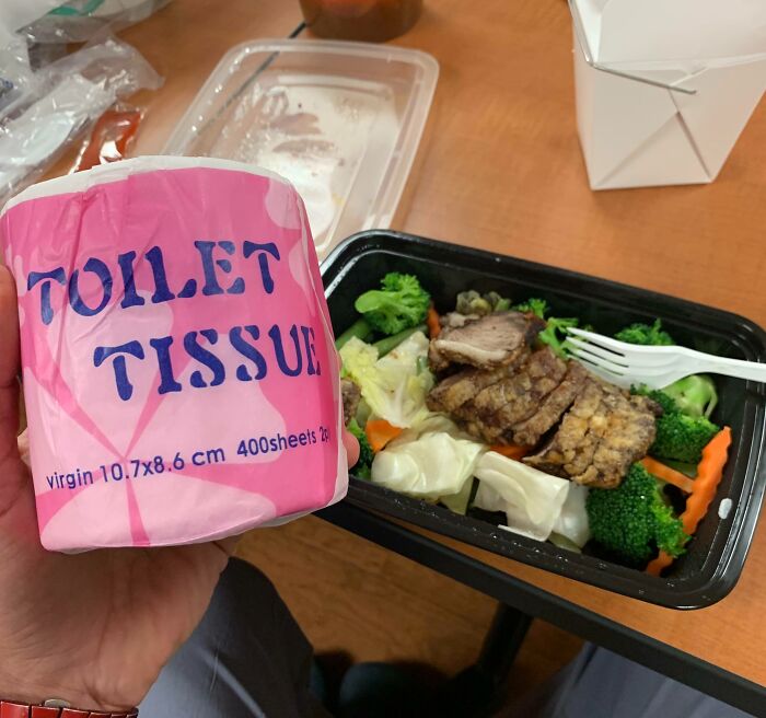 Toilet tissue held over a meal in a plastic container, representing cool products with surprises.