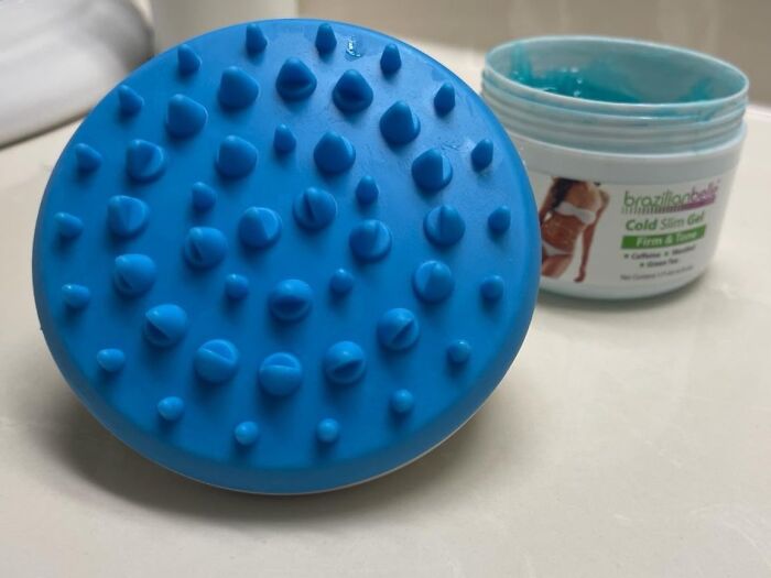 Blue massage tool for unavoidable body issues with a jar of firming gel in the background.