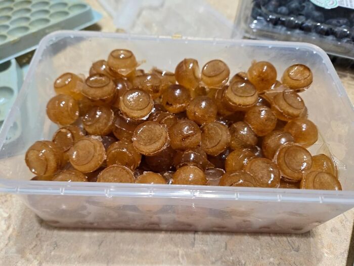 Container filled with round, golden gummy candies, a popular #TikTokMadeMeBuyIt item.