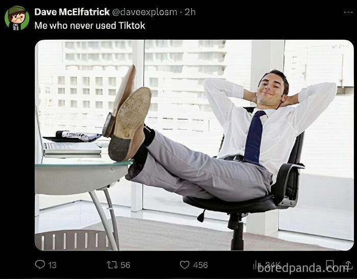 Man relaxing at work amid TikTok ban reactions, feet up on desk.