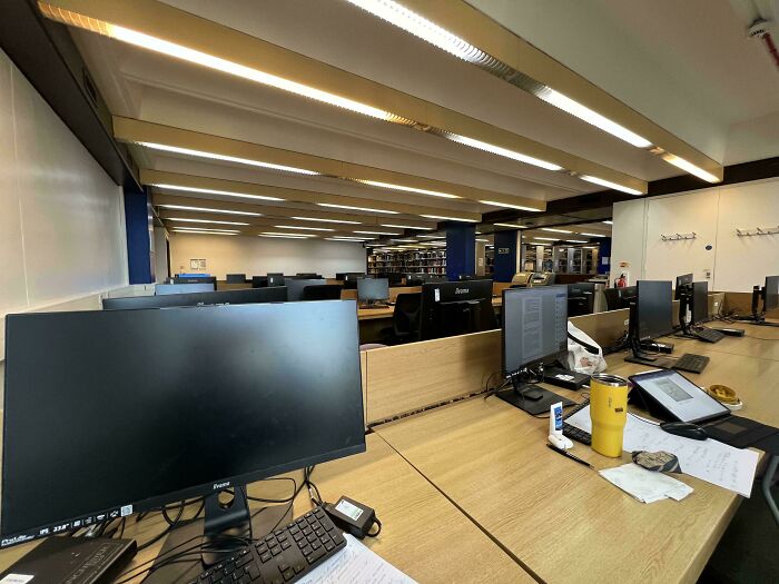 Empty office with cluttered desks and unattended computer, illustrating complete jerks behavior.