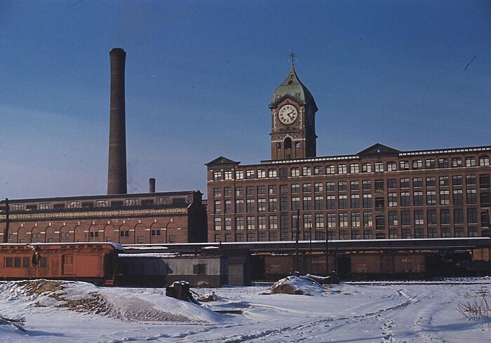 Historic factory building in snow, 1940 color photos capture industrial architecture under a clear blue sky.