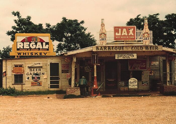 Vintage 1940 color photo of a rustic roadside store with signs for Regal whiskey and Jax beer.