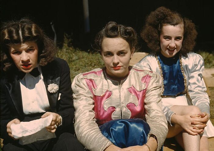 Three women in vibrant 1940 color photos, sitting outdoors, showcasing vintage fashion and hairstyles.