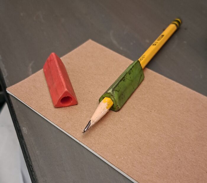 Gen X nostalgia: a worn-down pencil with a green grip and a red eraser on a desk.