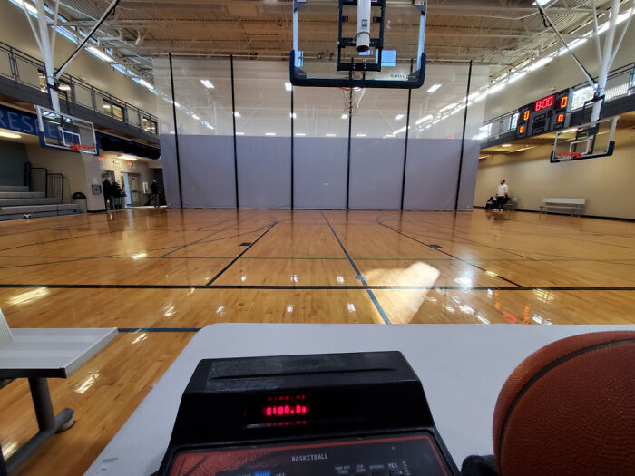 Empty basketball court with a ball and scoreboard, reflecting people being jerks theme.