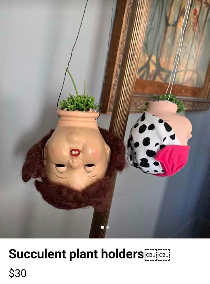 Creepy doll head planters with succulents for sale, hanging upside down.