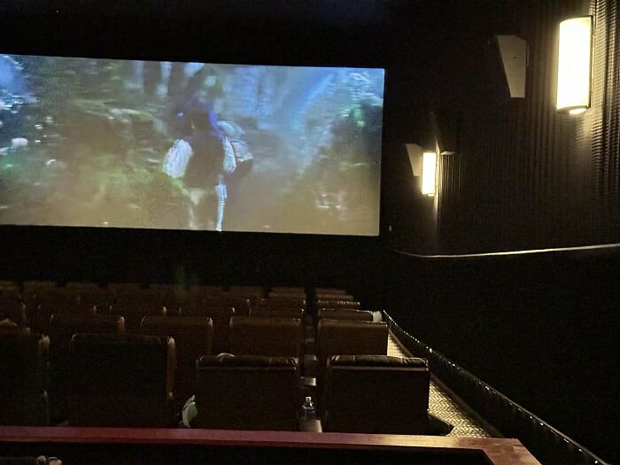 Empty theater with a movie playing, highlighting inconsiderate behavior.