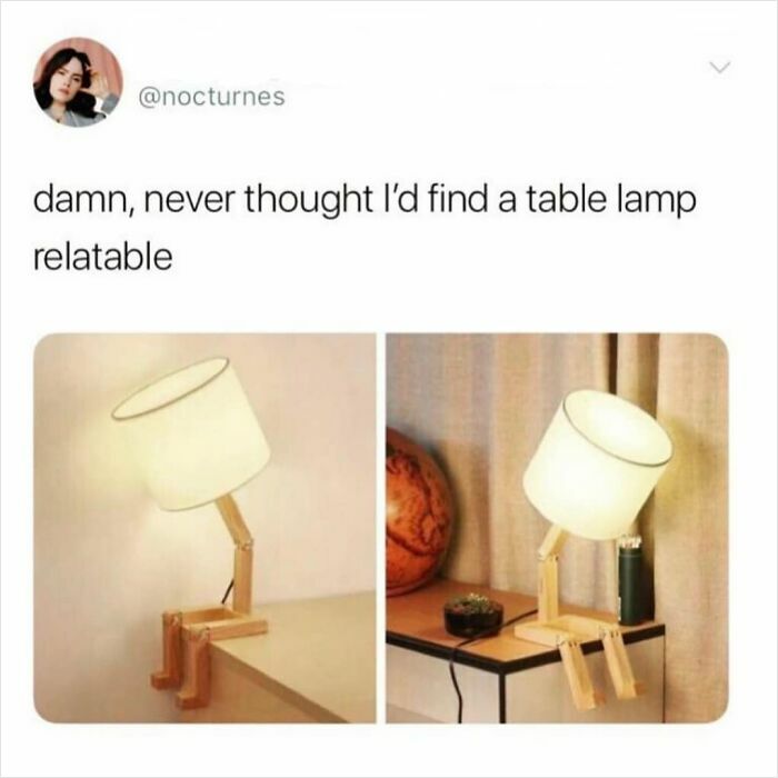 A table lamp with wooden legs sitting on a table, humorously relatable for introverts.