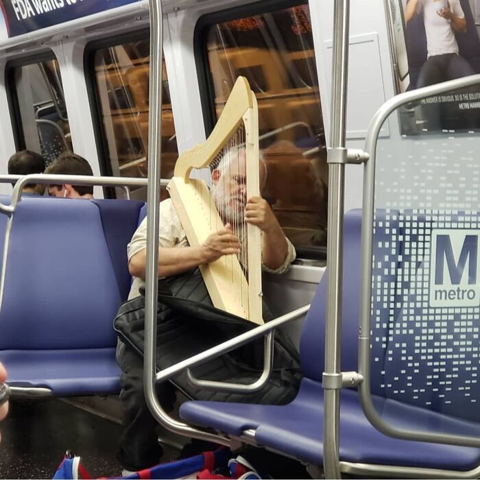 Man plays harp on subway, showcasing funny train passengers.