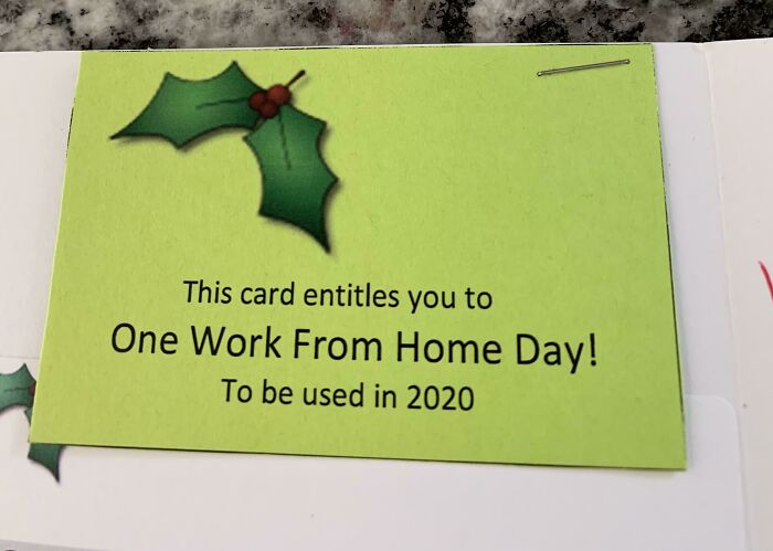 A card offering a single work from home day as a company gift bonus for 2020, decorated with holly.