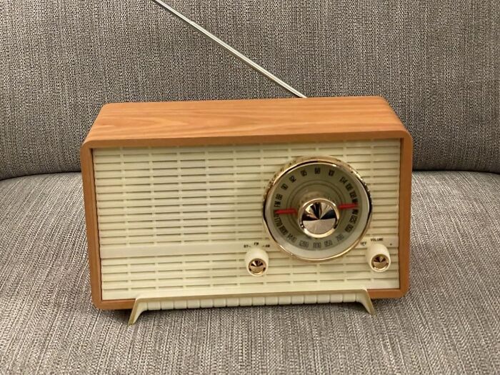 Retro Fever: Vintage tabletop radio with wooden finish and analog dial on a textured gray background.