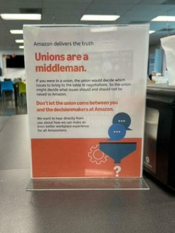 "Sign in an office reading 'Unions are a middleman' suggesting a boring dystopia theme."