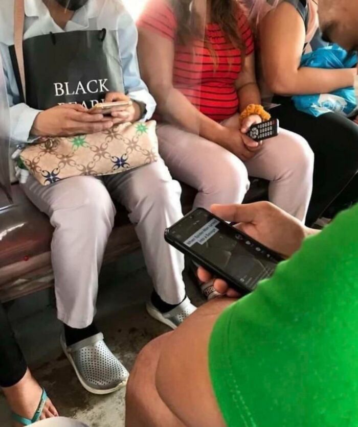 Commuters in a humorous scene on a crowded subway train, each focused on their phones.