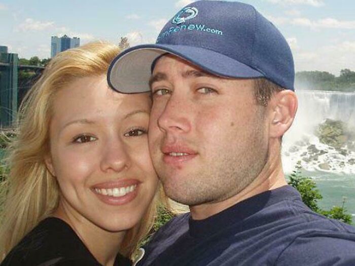 A couple posing together near a waterfall, representing true crime stories theme.