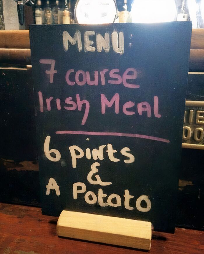 Chalkboard menu humorously lists "7 course Irish meal" as 6 pints and a potato, evoking quirky British humor.