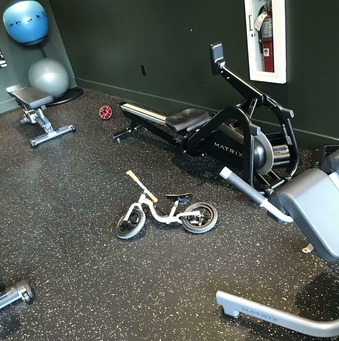 Gym with exercise equipment obstructed by a small bike, highlighting people being jerks.