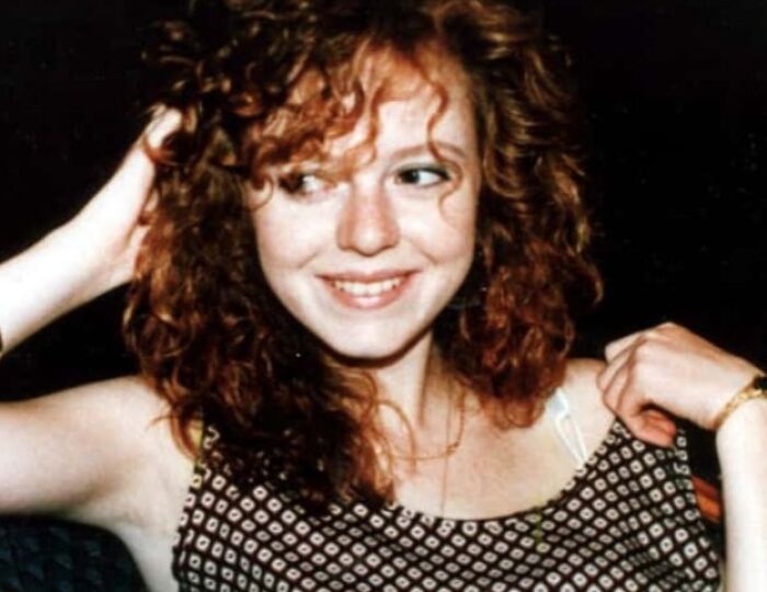 Woman with curly hair smiling, wearing a patterned top; connected to true crime stories and curiosities.