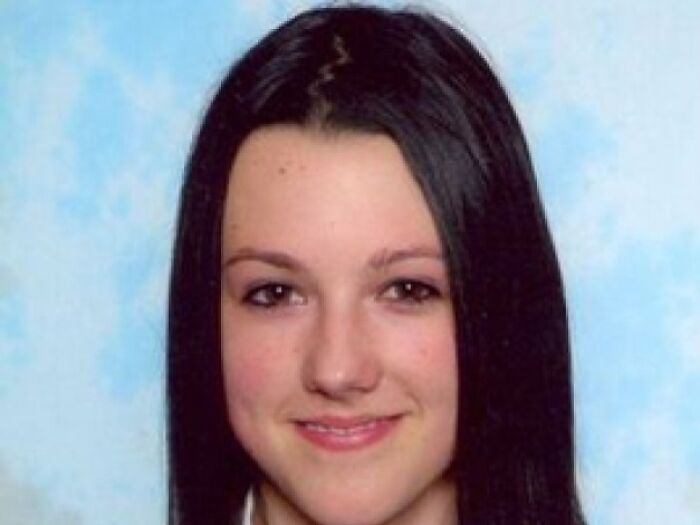 "Portrait of a young woman with true crime connection, smiling, against a soft blue background."