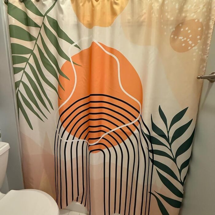 Abstract shower curtain with leaf design for renter friendly upgrades in a bathroom setting.