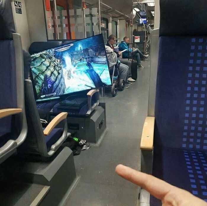 Funny subway passengers with a large gaming setup on the train.