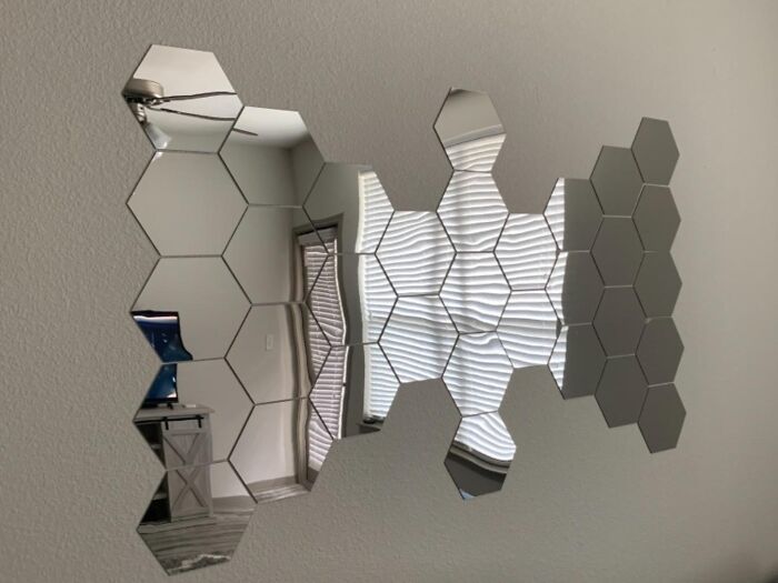 Hexagonal wall mirror tiles in a modern apartment interior.